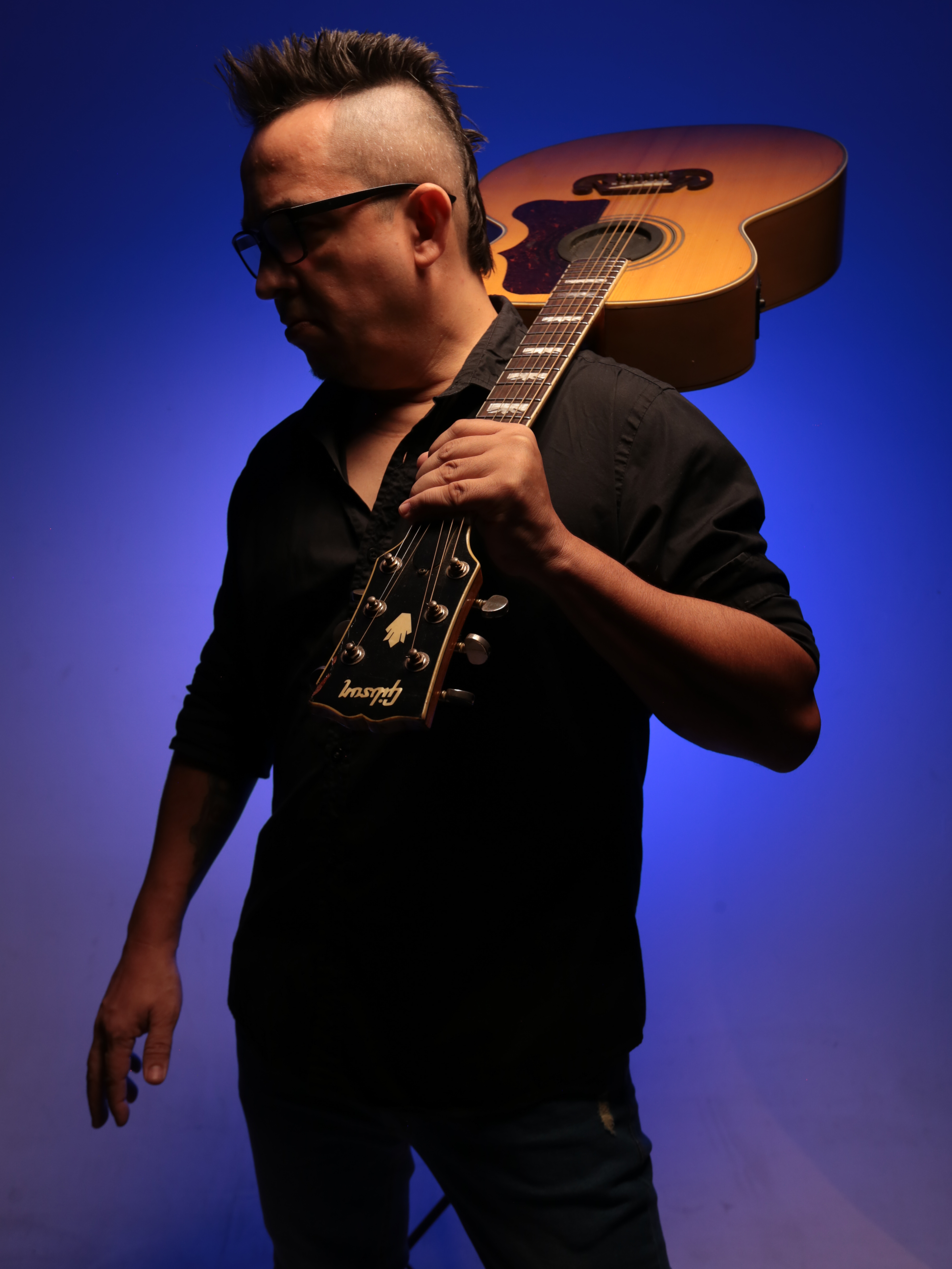 Sujeito Rock com violão Gibson e óculos escuros